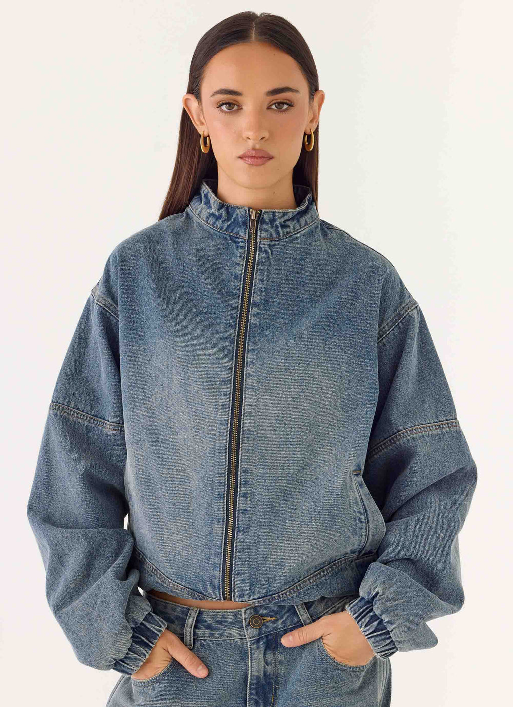 Women's blue denim bomber jacket with high collar and zip front