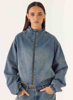Women's blue denim bomber jacket with high collar and zip front