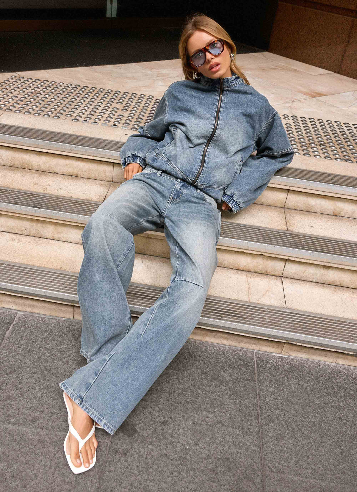 Women's blue denim bomber jacket with high collar and zip front
