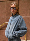 Women's blue denim bomber jacket with high collar and zip front