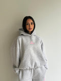 Women's light grey hooded sweatshirt with pink chest logo