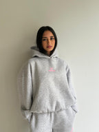 Women's light grey hooded sweatshirt with pink chest logo