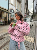 Women's pink cropped jacket with black polka dots, high collar and tie waist
