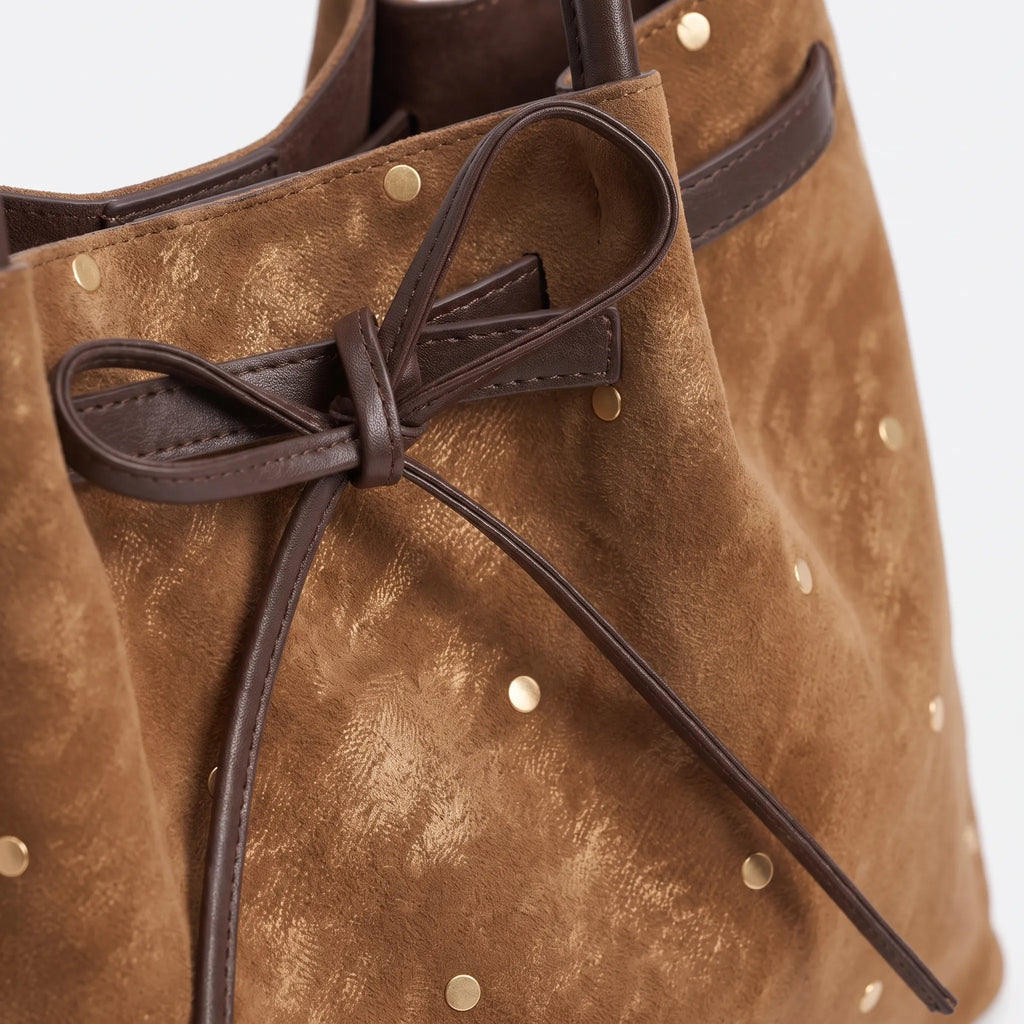 Women's flared tote bag with scattered studs, long handles and front bow tie detail