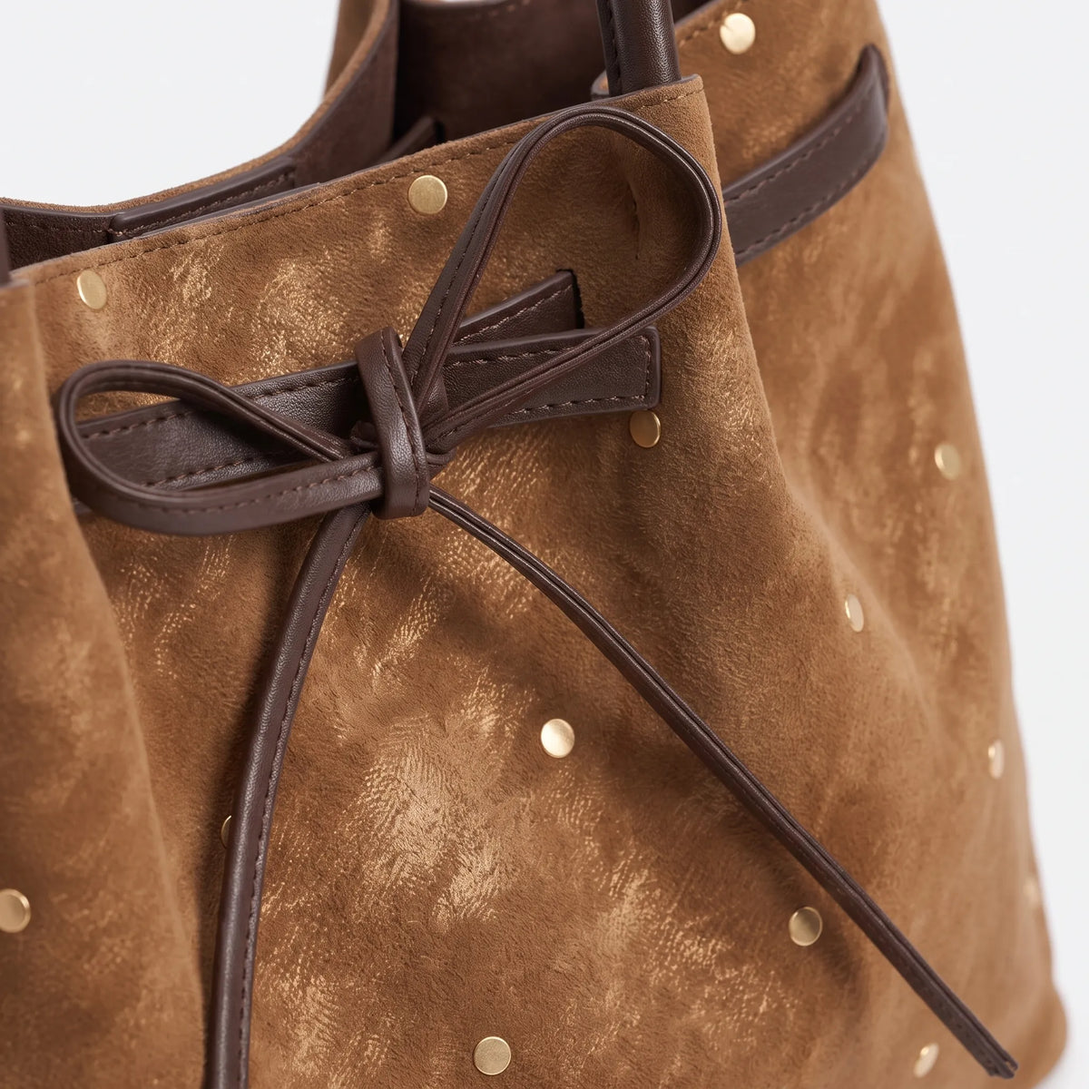 Women's flared tote bag with scattered studs, long handles and front bow tie detail