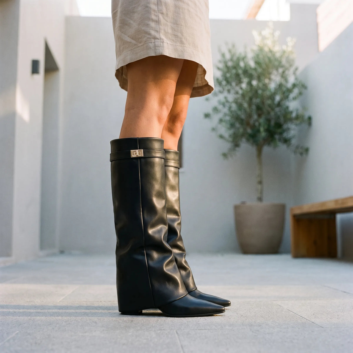 Black women's pointed toe knee high boots with buckle detail and low heels