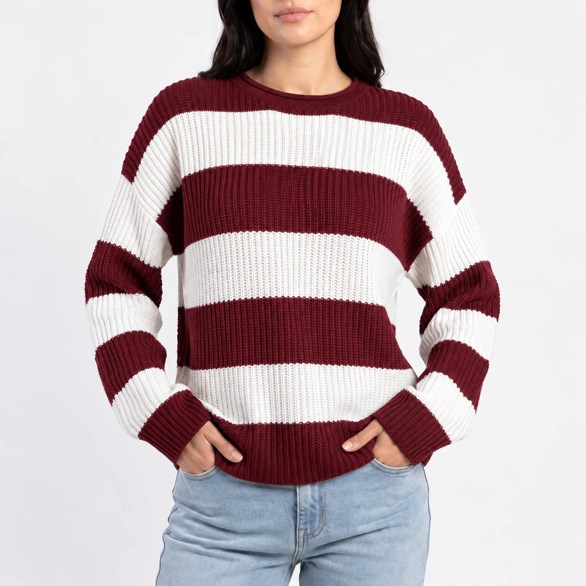 Woman wearing an oversized striped knitted jumper with a crew neck and long sleeves