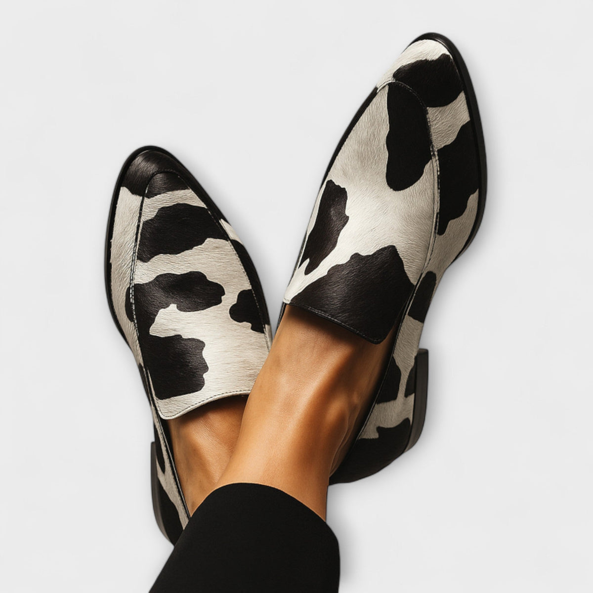Women's cow print slip-on loafers with almond toes and low heels