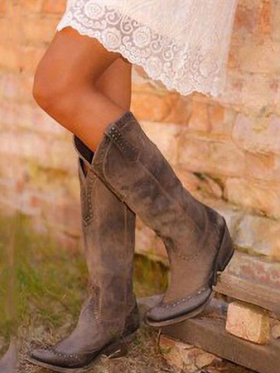 Tall studded Western cowboy boots with pointed toes and low heels