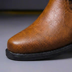 Men's ankle boots with cross-over buckled straps, metal studs and low heel