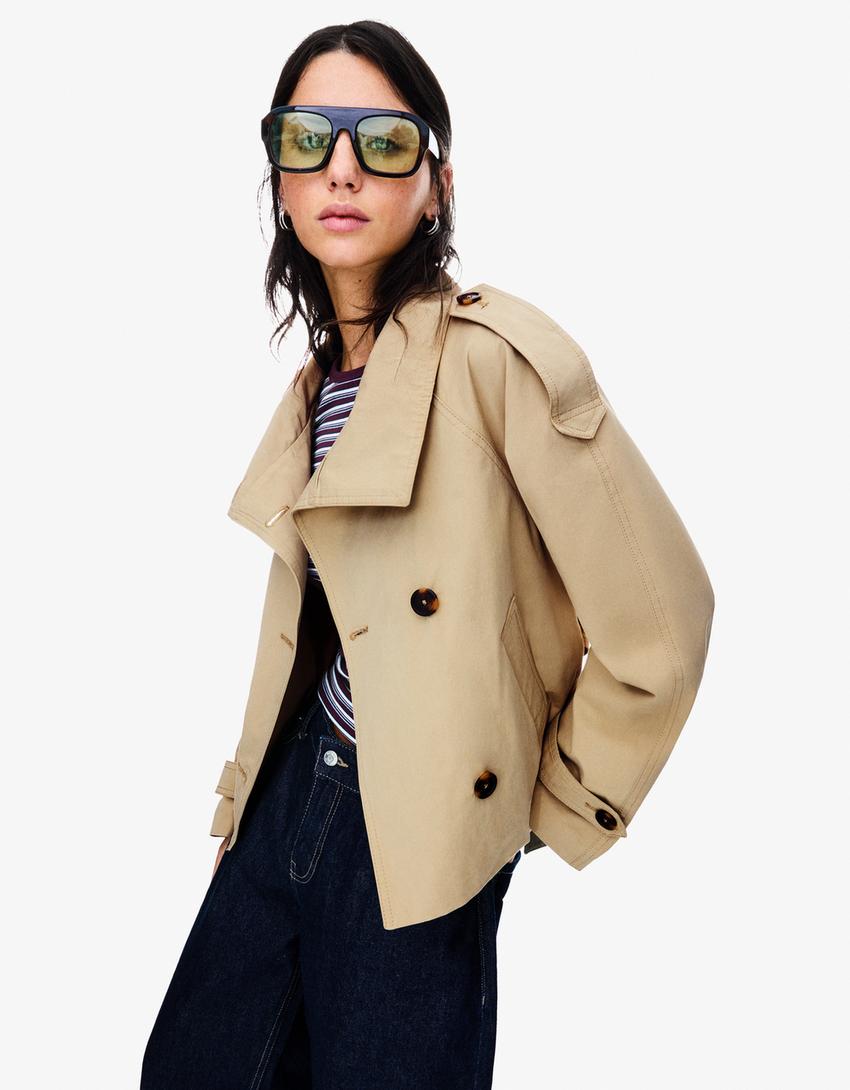 Women's cropped trench jacket with high collar, buttons, belt and shoulder tabs