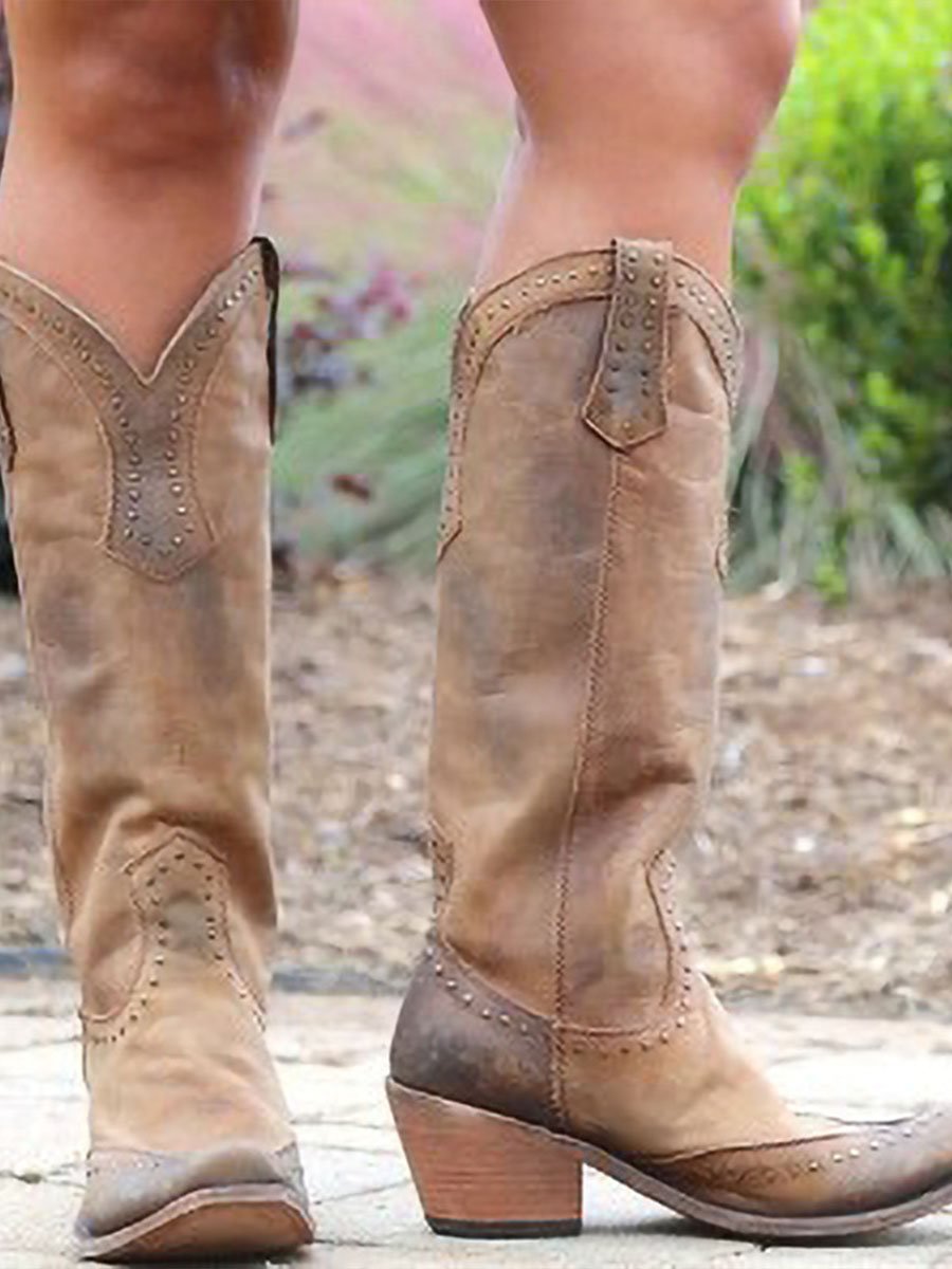 Tall studded Western cowboy boots with pointed toes and low heels