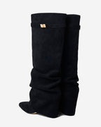Women's black slouchy knee-high boots with pointed toes and buckle strap details
