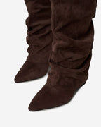 Women's brown slouchy knee-high boots with pointed toes, low heels and buckle straps