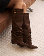 Women's brown slouchy knee-high boots with pointed toes, low heels and buckle straps