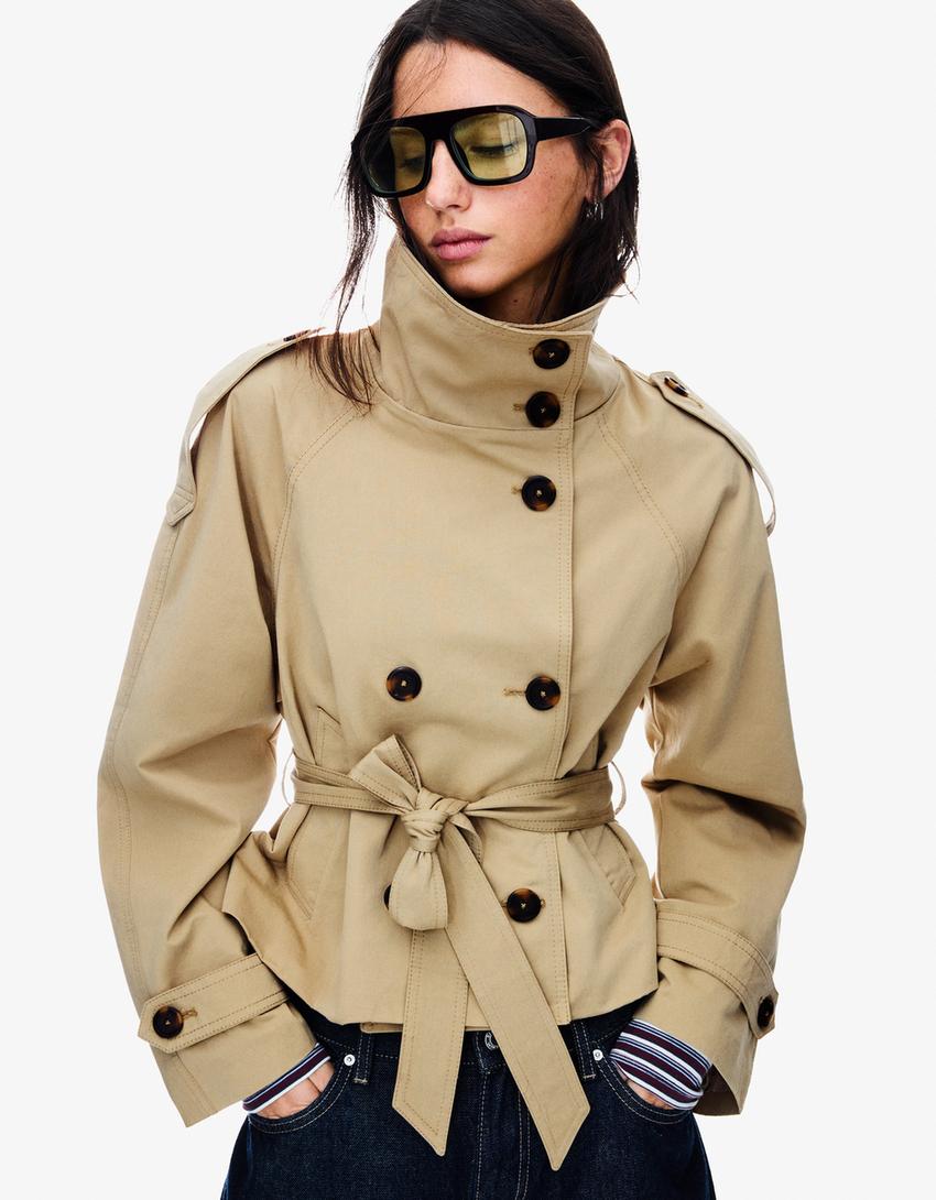 Women's cropped trench jacket with high collar, buttons, belt and shoulder tabs