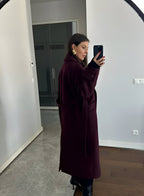 Women's burgundy long belted trench coat with double-breasted buttons and lapels