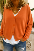 Women's long-sleeved V-neck button cardigan shown layered over a white top and jeans