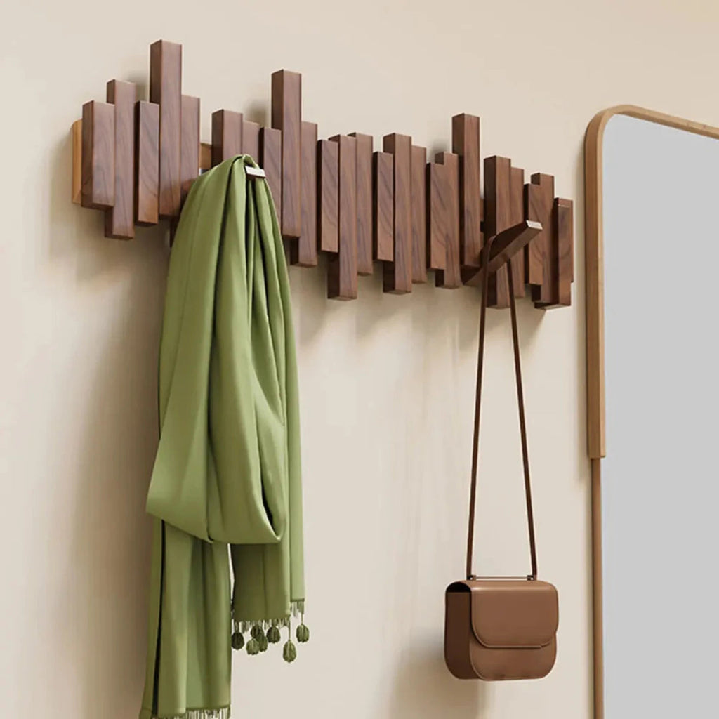 Wall-mounted slatted wooden coat rack with multiple hooks, umbrella and coat