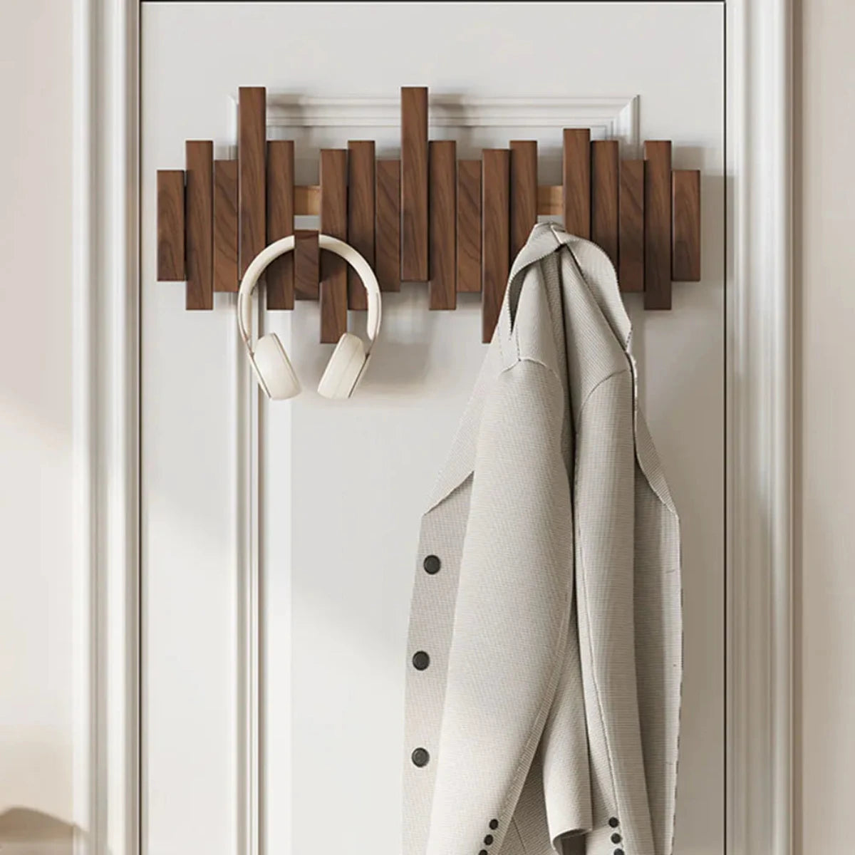 Wall-mounted slatted wooden coat rack with multiple hooks, umbrella and coat