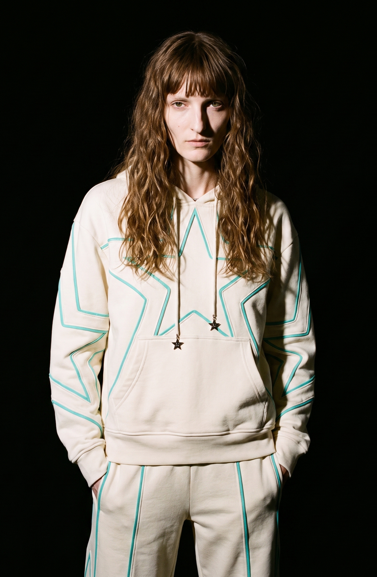 Cream hoodie with turquoise outlined star motifs, drawstring hood and front kangaroo pocket