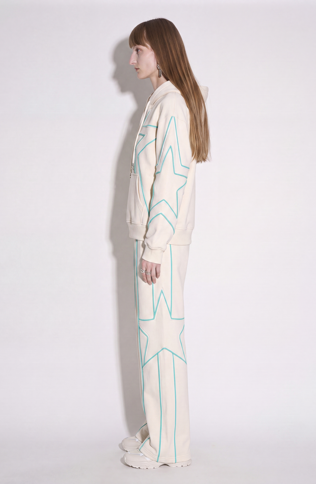 Cream hoodie with turquoise outlined star motifs, drawstring hood and front kangaroo pocket