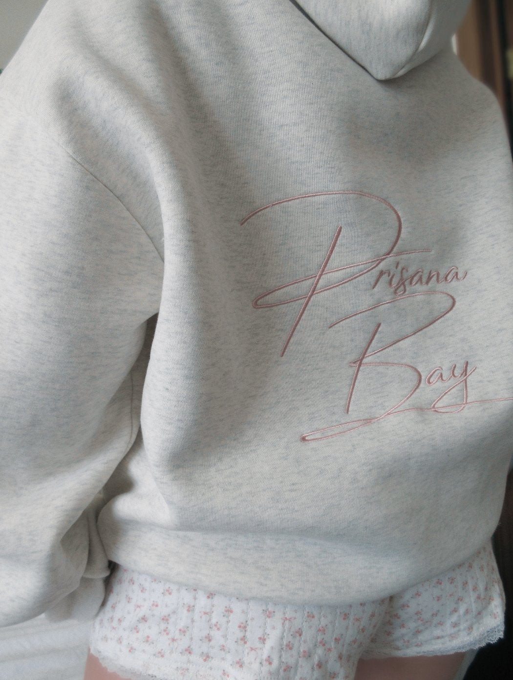 Women's light grey hooded sweatshirt with pink embroidery and floral-lined hood
