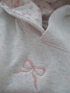 Women's light grey hooded sweatshirt with pink embroidery and floral-lined hood