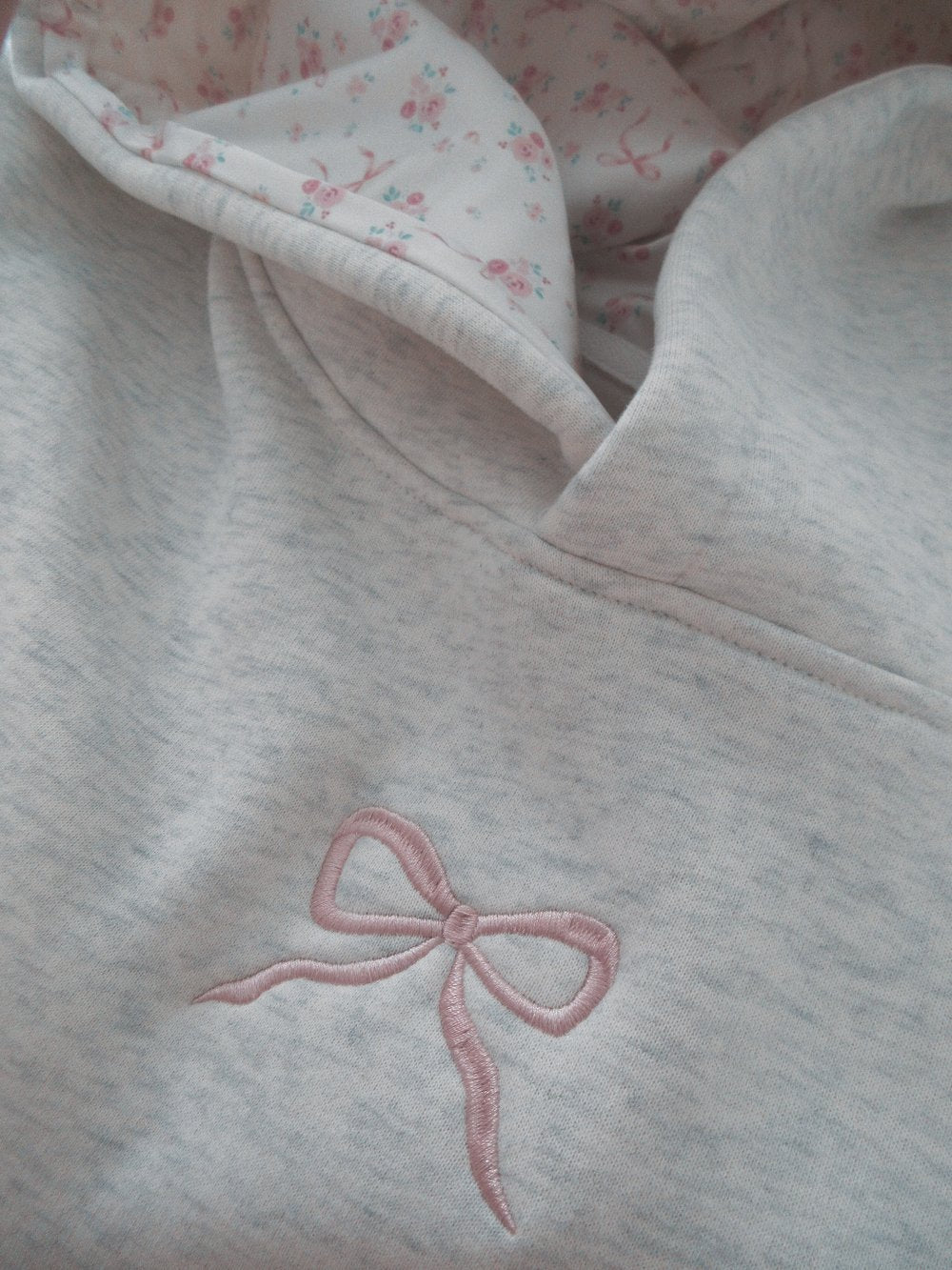 Women's light grey hooded sweatshirt with pink embroidery and floral-lined hood