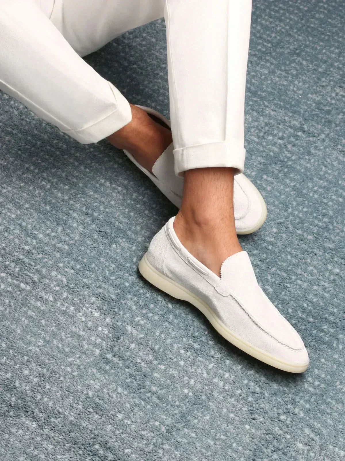 Men's white slip-on loafers with moc toe stitching and flat soles