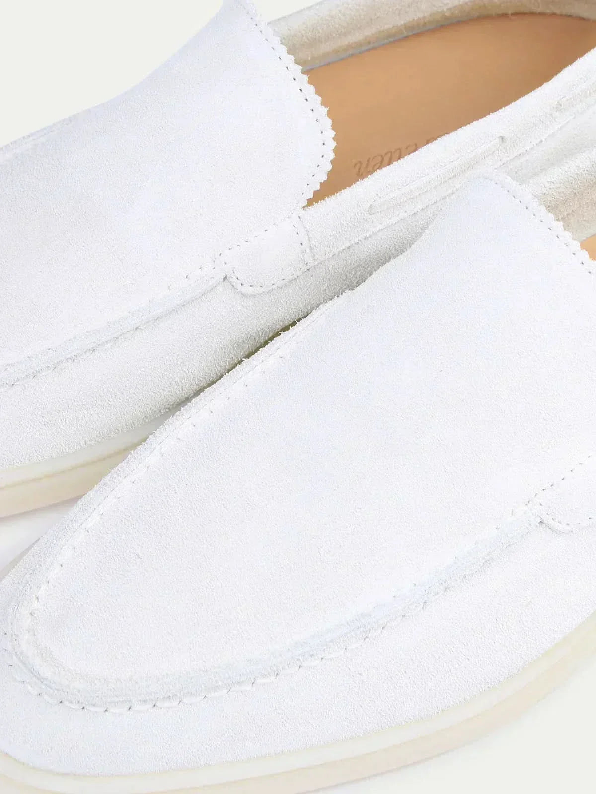 Men's white slip-on loafers with moc toe stitching and flat soles