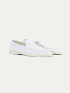 Men's white slip-on loafers with moc toe stitching and flat soles