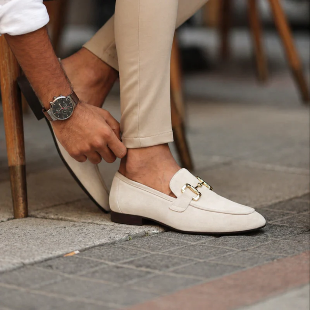 Men's slip-on loafers with decorative buckle and low heel shown in beige and black
