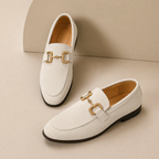 Men's slip-on loafers with decorative buckle and low heel shown in beige and black