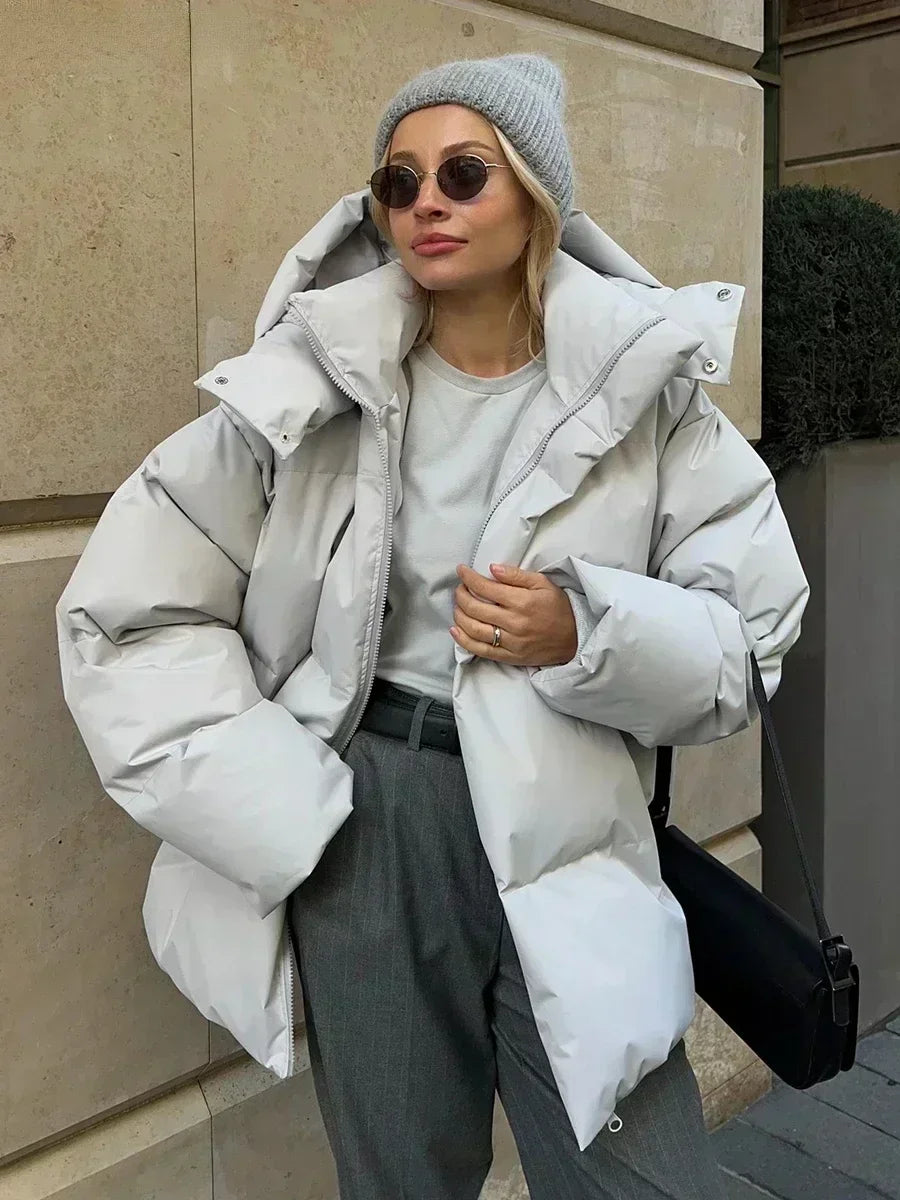Women's oversized hooded puffer jacket with long sleeves and side pockets