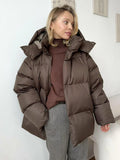 Women's oversized hooded puffer jacket with long sleeves and side pockets