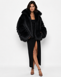 Woman wearing a black long-haired fur coat with a wide collar