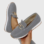 Women's textured slip-on loafers with decorative metal buckle and flat sole