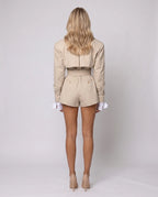 Women's beige long-sleeve trench-style romper with lapels and a belted waist